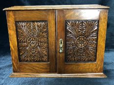 Edwardian smokers cabinet with carved decoration, two internal drawers and two pipes in racks,