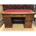 Knee hole desk with read leather top and nine drawers, approx 119cm x 60cm x 69cm tall