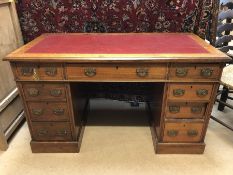 Knee hole desk with read leather top and nine drawers, approx 119cm x 60cm x 69cm tall