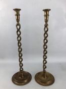 Two large brass twisted stem candlesticks with flared candle holders with circular bases