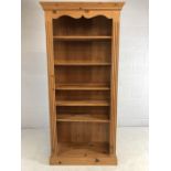Tall pine bookcase with carved detailing, approx height 193cms, width 92cms, depth 31cms.