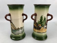 Pair of Longpark cylindrical vases with loop handles, one with 'Cockington Forge Torquay' design,