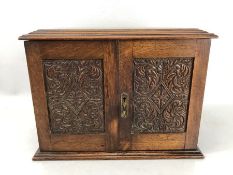 Oak smokers cabinet with carved detailing to doors and hinged lid revealing ceramic tobacco jar