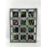 Leaded stained glass panel with abstract green and red square design, approx 49cm x 38cm, sold on