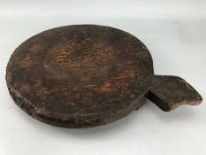 Large rustic wooden chopping board, approx 30cm in diameter, on three feet with handle to side