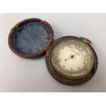 Brass cased pocket barometer inscribed 'Compensated', approx 5cm in diameter, in original leather