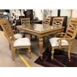 Light wood glass-topped extending dining table with carved detailing and six chairs with upholstered