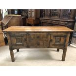 Carved oak sideboard with metal detailing, two drawers to the centre, flanked by two cupboards