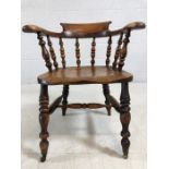 Smokers bow / elbow chair with spindled back, turned legs and castors to front, approx width 66 cm