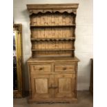 Antique pine dresser with three shelves over, two drawers and two cupboards below, with carved