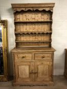 Antique pine dresser with three shelves over, two drawers and two cupboards below, with carved