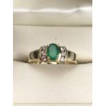 14ct Gold ring set with Oval faceted Emerald and with three Diamonds to each shoulder (size 'L')