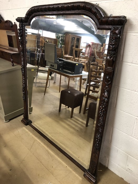 Very large bevel-edged mirror with ornate carved detailing (in the manner of Green Man). Carvings to