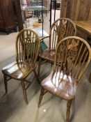 Three pine wheelback chairs to include one carver