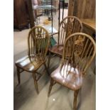 Three pine wheelback chairs to include one carver