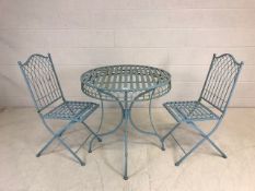 Round metal garden table, approx diameter 75cm, with two matching folding garden chairs, painted