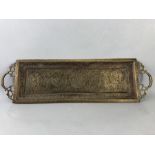 Oblong brass embossed tray with remnants of original colour pigments, two handles, depicting