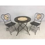 Metal latticework bistro table with inlaid decorated panels with two matching chairs