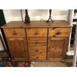 Pine sideboard on bun feet with six drawers and two cupboards, approx 116cm x 43cm x 81cm tall