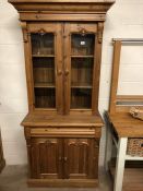 Pine dresser with glazed two door shelved cupboard over and two door cupboard under, with carved