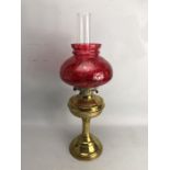 Brass based oil lamp with chimney and cranberry shade