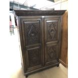 Oak wardrobe with carved detailing to top and panels with internal hanging rail and hooks.