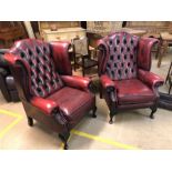 Pair of red leather wing back arm chairs Approx 80 cm wide x 110cms tall.