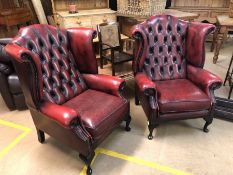 Pair of red leather wing back arm chairs Approx 80 cm wide x 110cms tall.