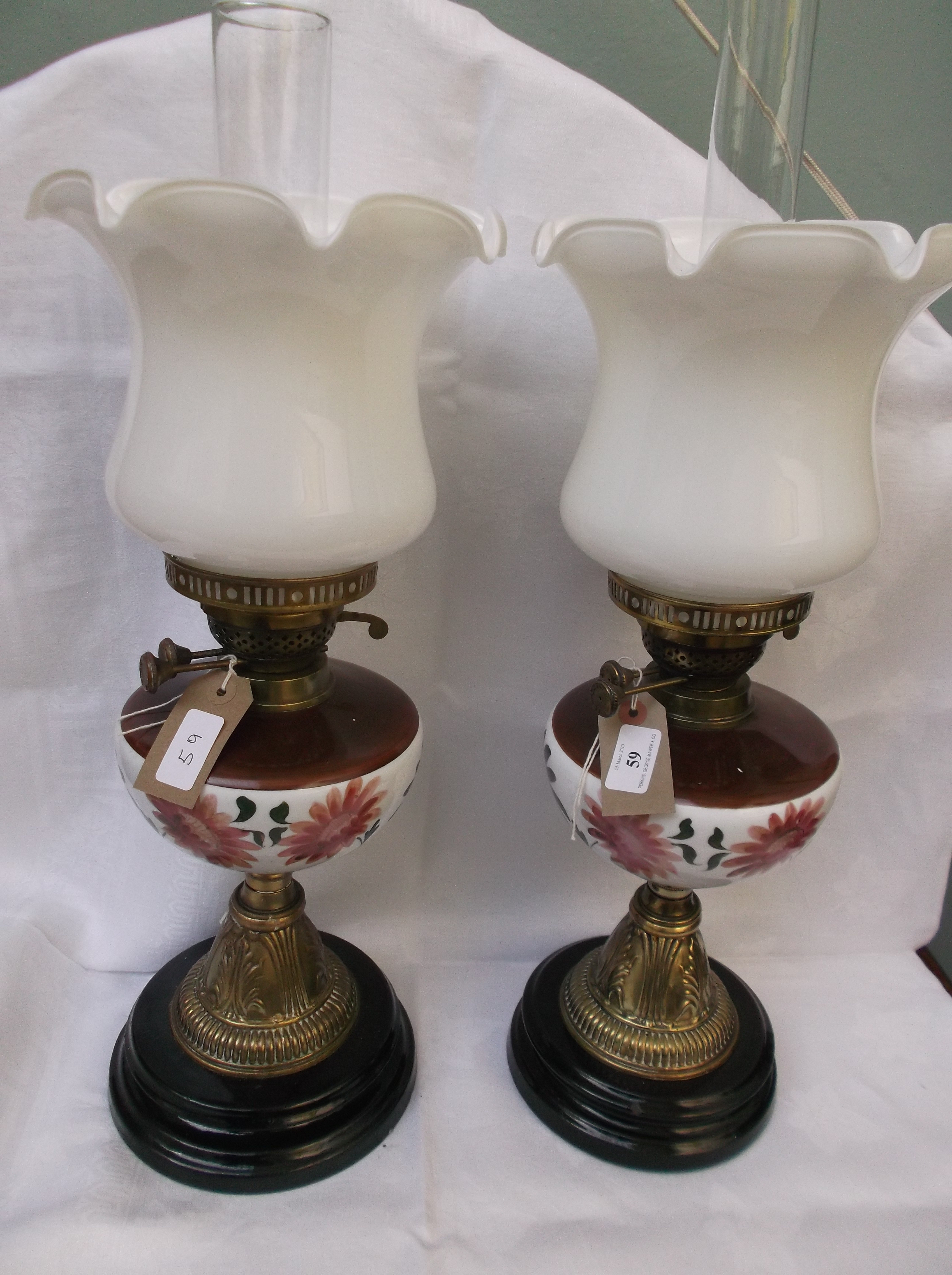 Pair of table lamps on circular ebonised and brass plinths,