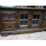 Low rectangular topped cabinet fitted 2 small glazed leaded astragal doors and 2 pedestal cupboards