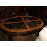 Oval topped low drinks table inset 4 bevel edged glazed panels on solid shaped feet
