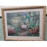 Large cream and gilt framed signed coloured print of summer flowers around patio in garden
