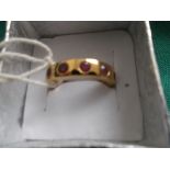 Yellow metal eternity ring set with rubies (size L)