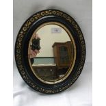 Small Edwardian oval wall mirror in decorative gilt and ebony frame