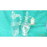 2 clear glass Mary Gregory style handled pouring vessels each with glass stopper