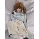 Porcelain pot headed doll, fixed eyes and light brown curled hair in blue pinafore dress,