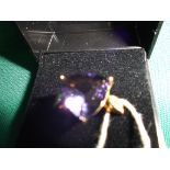 Yellow metal dress ring with purple triangular set stone (size T),