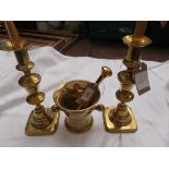 Pair of brass candlesticks and a brass pestle and mortar