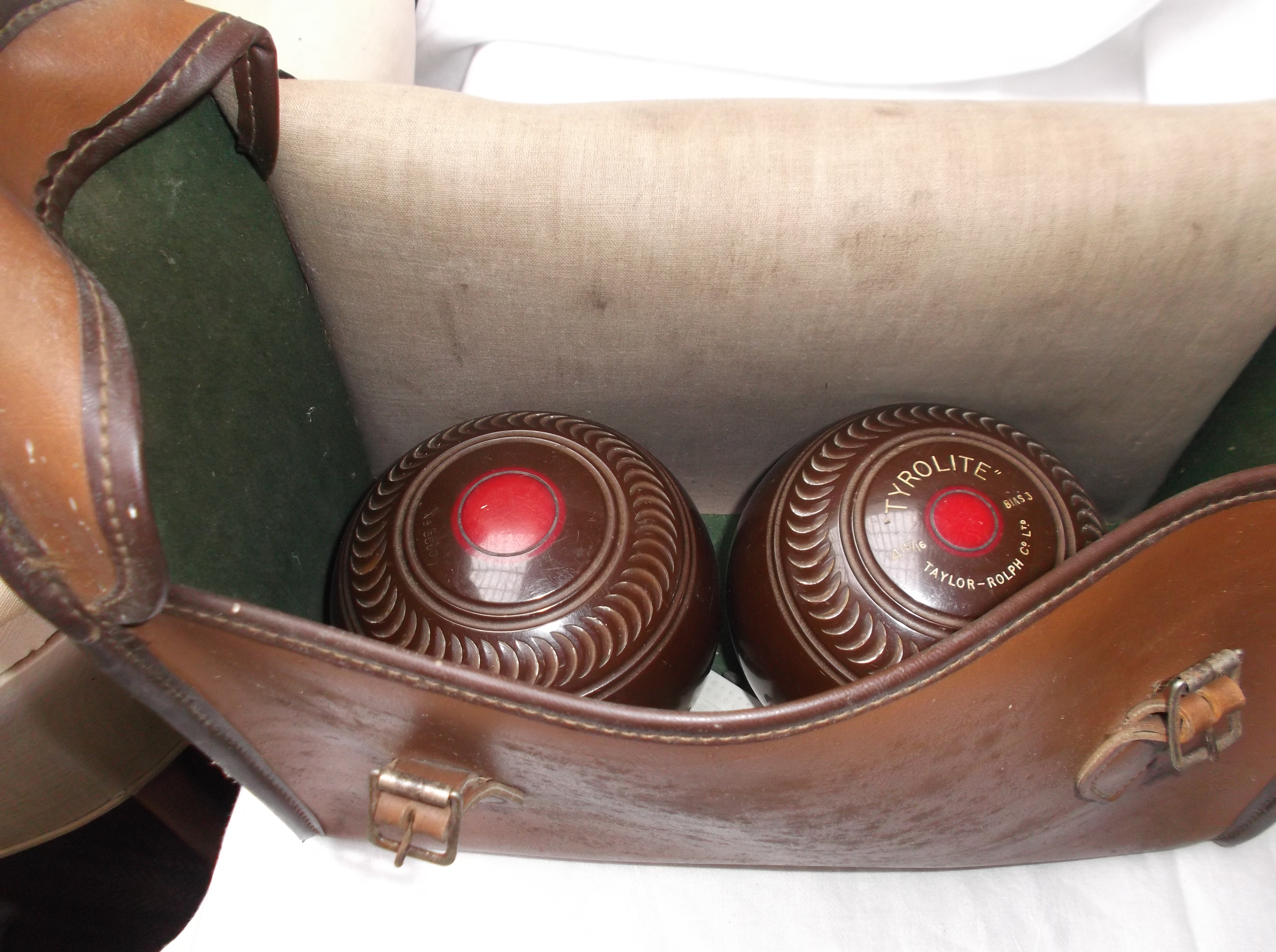 Pair of brown tyrolite lawn bowls with steel measure all in light brown plastic carrying case