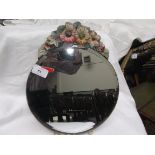 Circular bevel edged mirror with raised coloured floral decoration to stop