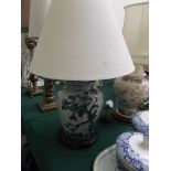 Blue urn shaped based oriental patterned table lamp on circular plinth with beige parchment shade