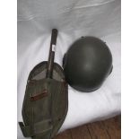 American WW II helmet and a green canvas firemans satchel and spade