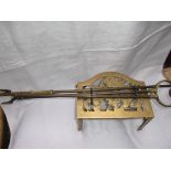 Brass trivet and a pair of long handled brass fire irons