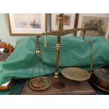Pair of brass balanced scales with set of 6 circular brass weights all on rectangular oak plinth