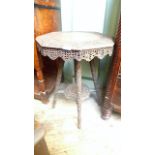 Octagonal topped heavily carved sidetable (approx 18" dia) on four carved splayed feet united by