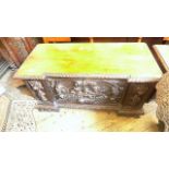 Coffer chest (52" x 19 1/2") with heavily carvings of animals and mask heads to front