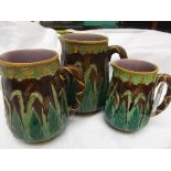 Set of 3 green, yellow and brown ground graduated jugs,