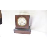 Enamel dialed mantleclock in distressed wooden case,