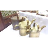 Pair of graduated brass water cans and another