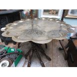 Ornate circular beaten brass table stand on 6 shaped turned feet (tray top 24" diam.